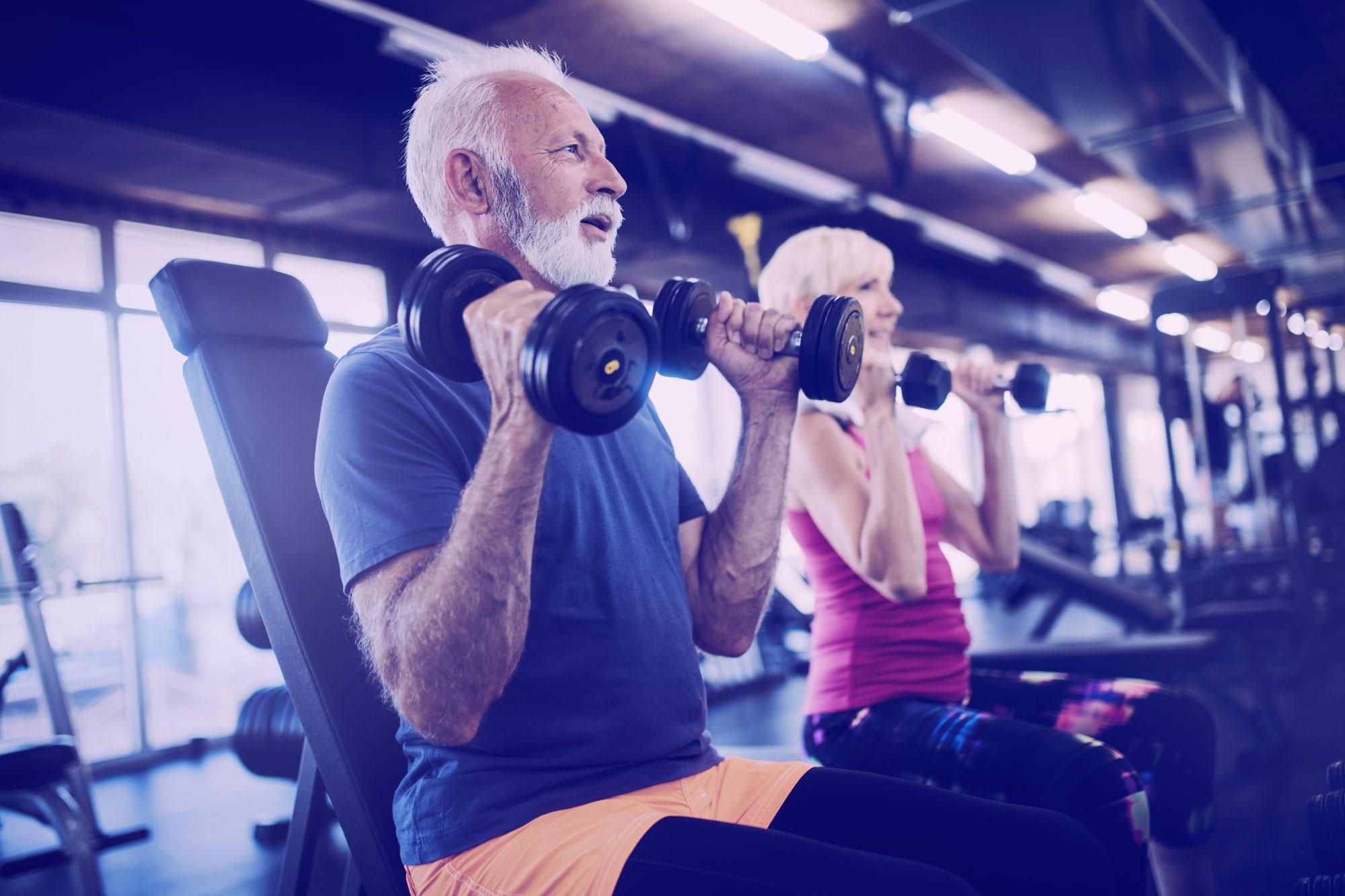 Senior people doing exercises in gym to stay fit
